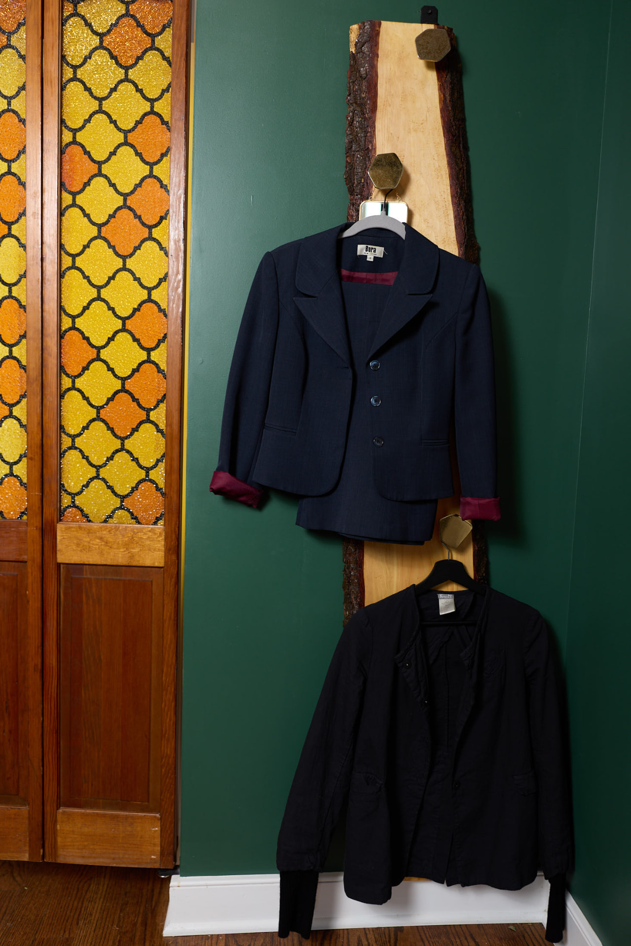 A blazer on the live-edge coat rack beside the stained-glass door at the Galbo Family Law office in Milford, Connecticut